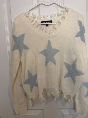 Cream colored knit sweater with baby blue star pattern & frayed hem and neckline